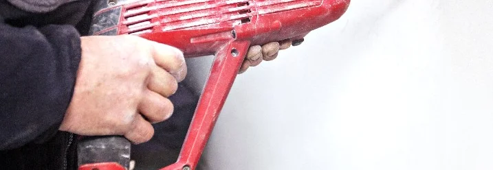 Person bohrt mit Bohrhammer in Wand